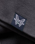 Navy Benchmade Butterfly Logo Label - Close-up Detail on Grey Cotton Fabric | Benchmade Knife Co.