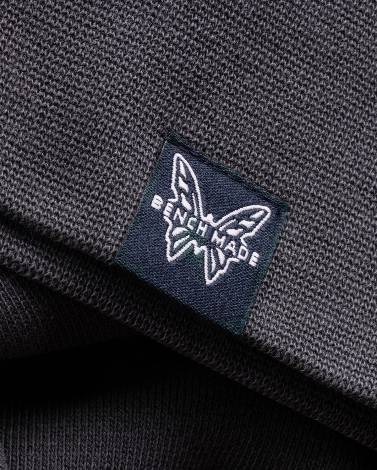Navy Benchmade Butterfly Logo Label - Close-up Detail on Grey Cotton Fabric | Benchmade Knife Co.