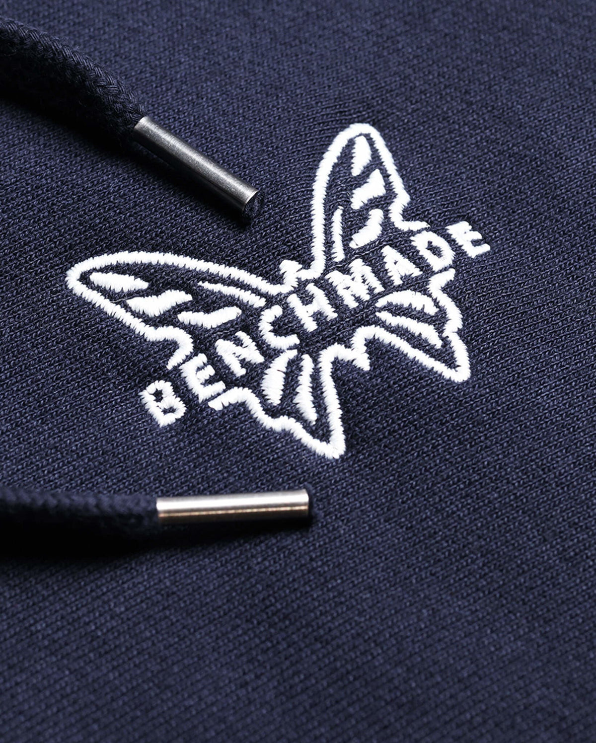 White Embroidered Benchmade Butterfly Logo - Close-up Detail with Metal Drawcord Tips | Benchmade Knife Co.